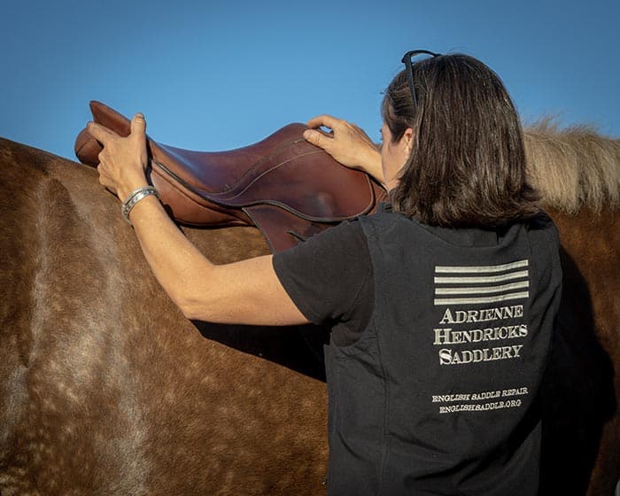 Adrienne Hendricks saddle fitting a horse